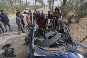 Palestinians inspect the wreckage of a car hit by an Israeli attack on Salah al-Din Street in Deir el-Balah, central Gaza. The vehicle was reportedly carrying six security guards helping to distribute aid