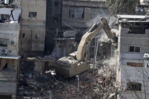 An Israeli army excavator demolishes a residential building in the Tulkarem camp for Palestinian refugees during an ongoing Israeli military operation in the occupied West Bank on February 18, 2025.