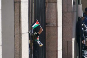 Students from inside the gates of Columbia University wave Palestinian flags through the bars, April 22, 2024.