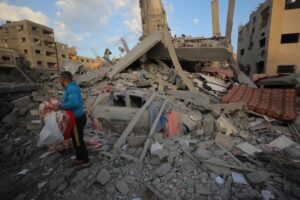 After an Israeli air strike hit the home of the Abu Mershud family in the Nuseirat refugee camp, northeast of Deir el-Balah in central Gaza, killing seven people, Palestinians gather items from the debris on March 18, 2025