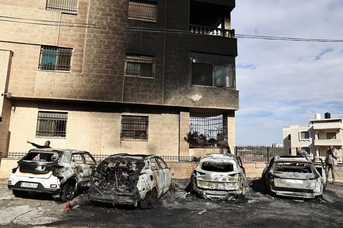 People check burnt vehicles at the site of a reported attack by Israeli settlers in a residential area on the outskirts of Ramallah city in the occupied West Bank, on November 4, 2024.