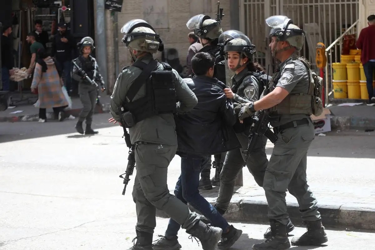 Israeli forces detain a Palestinian child during a raid as the army restrict the movement of citizens by closing shops on the third day of Passover in Hebron, West Bank on April 16, 2025.