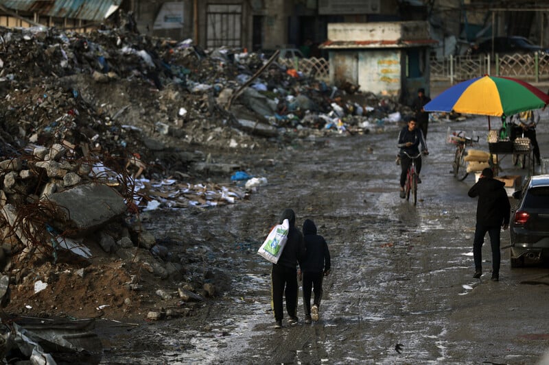 Trash piles up on every corner, rotting under the sun, releasing a stench that clings to the air.