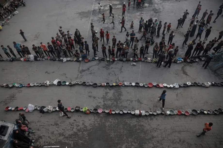Palestinians, struggling with hunger, form lines to receive hot meals in Gaza’s al-Zeitoun neighborhood on July 31, 2025, with no guarantee that there will be enough to feed everyone.