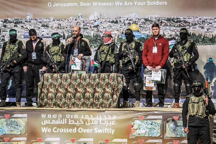 Fighters of the Islamic Jihad and the Ezz al-Din Al-Qassam Brigades, the military wing of Hamas, stand on a stage before the release of Israeli hostages, in Khan Younis, on Feb. 15, 2025.