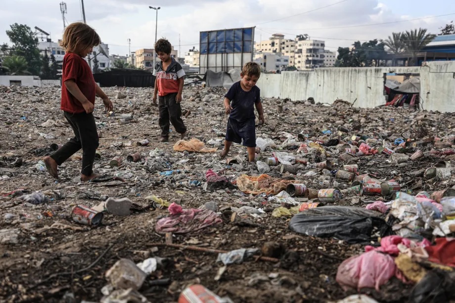 Palestinian children search for food scraps among waste material in Gaza City, Gaza on July 30, 2025.