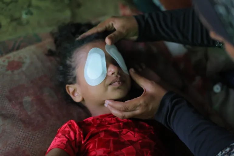 A Palestinian mother administers care to her 4-year-old daughter, who lost her vision in an Israeli strike