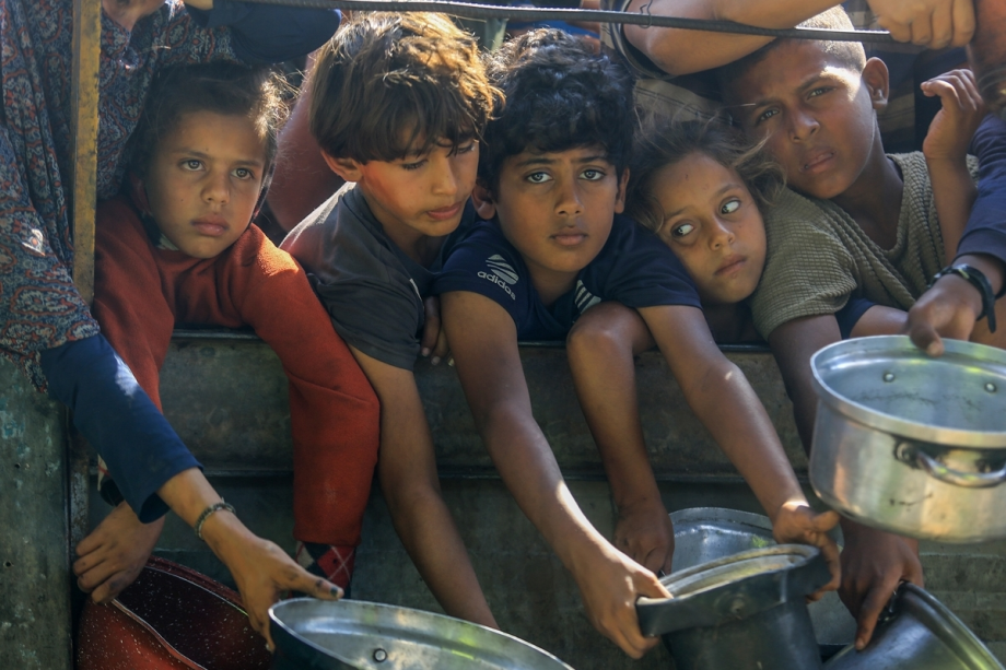Palestinians including children, wait in long queues to receive hot meals distributed by charity organizations at al-Mawasi area in Khan Younis, Gaza on November 5, 2025.