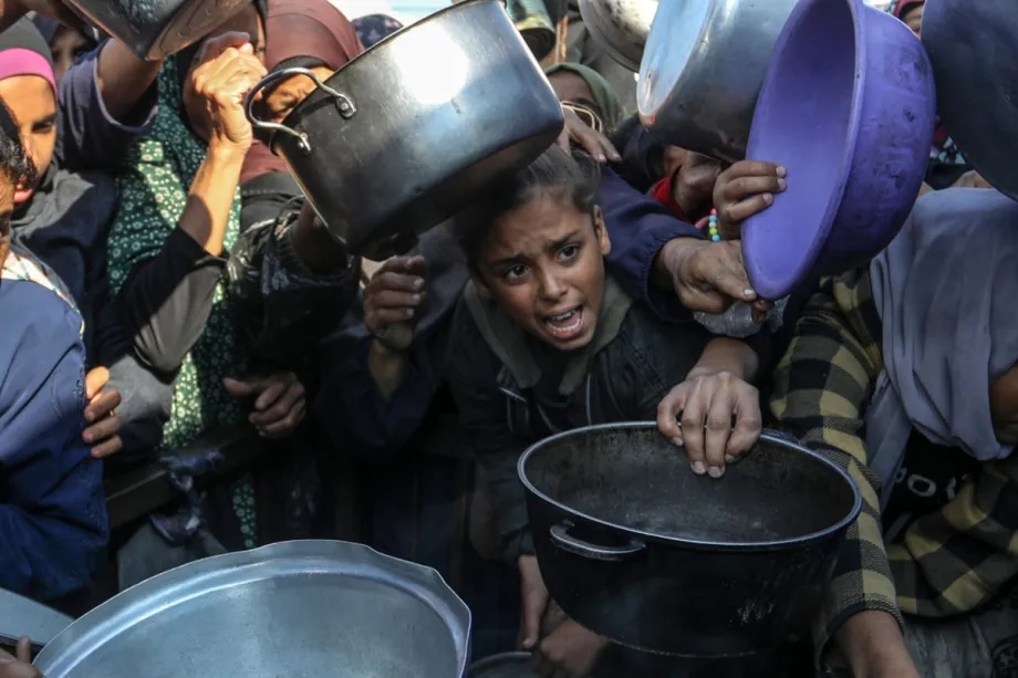 Displaced Palestinians, who struggle with hunger, wait to receive hot meal, distributed by charity organizations, in al-Mawasi region of Khan Younis, Gaza on December 17, 2025.