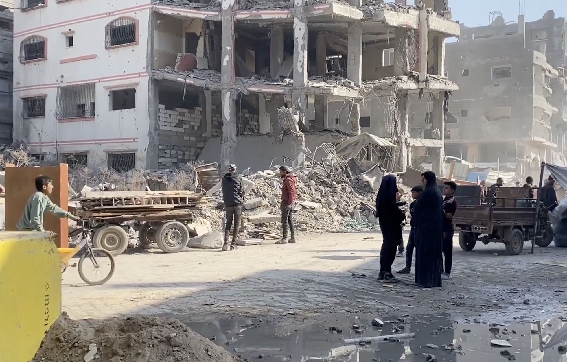 Palestinians walk in the neighborhoods of Al-Tuffah and Al-Shujaiya, where a yellow marker suddenly appeared, indicating Israel's takeover of more of Gaza.