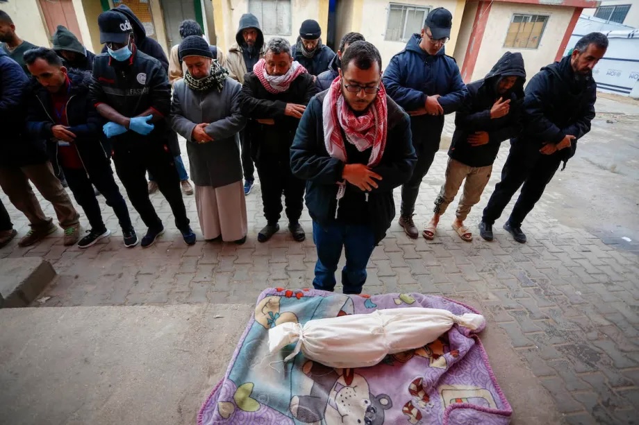 Palestinians gather to pray over the small body of an infant who died as a result of severe cold weather in Deir al Balah, Gaza on January 13, 2026.