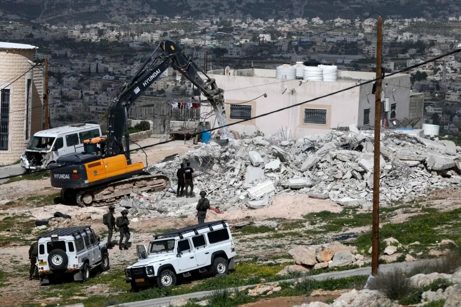 Israeli soldiers take security measures as the army demolishes a Palestinian home claiming it is “unlicensed” in the village of Beit Awwa near Hebron, West Bank on February 11, 2026.
