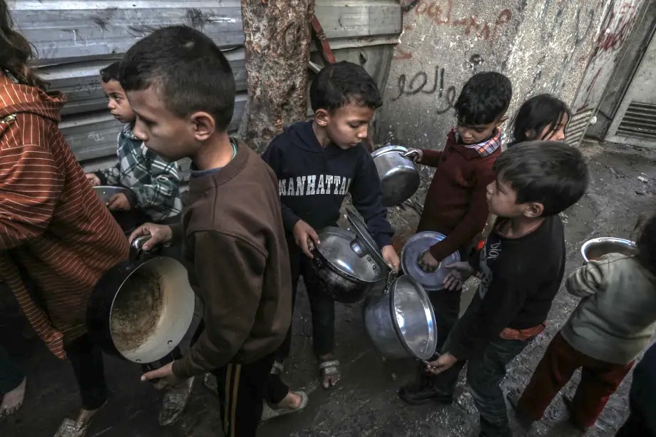 Palestinians including children wait to receive hot meal, distributed by a charity organization, in Khan Younis, Gaza on February 10, 2026.