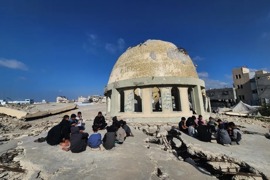 Palestinian children read the Quran at the heavily damaged Al-Habib Mohammed Mosque, destroyed in Israeli attacks, as they wait for iftar during the holy month of Ramadan in Khan Younis, Gaza on February 21, 2026.