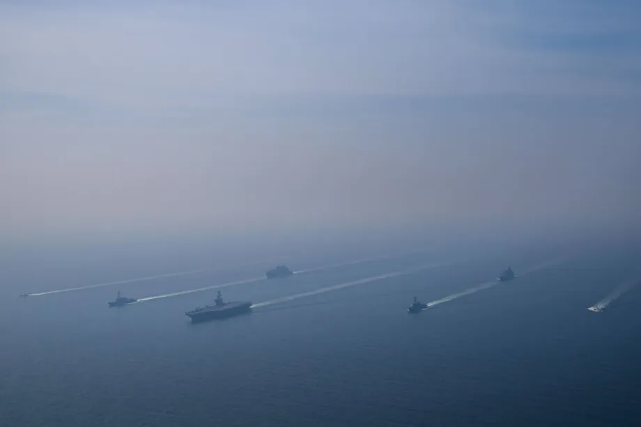An aerial view of the USS Abraham Lincoln Carrier Strike Group while operating at the Arabian Sea, escorted by two military replenishment ships and two U.S. Coast Guard vessels, as fighter jets from Carrier Air Wing Nine conducted flight operations overhead in the Arabian Sea, on February 6, 2026.