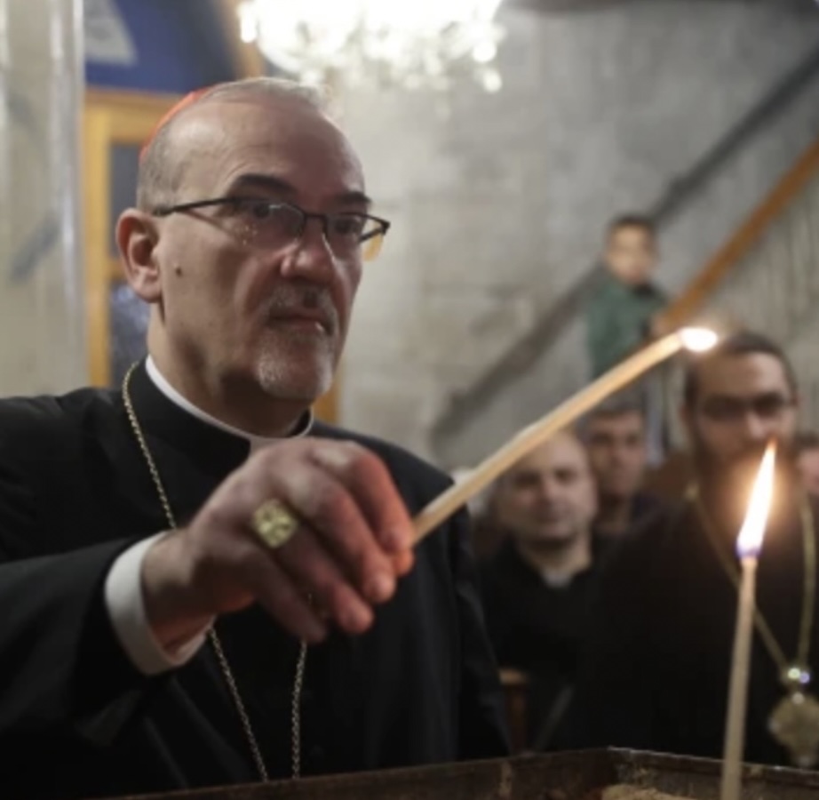 The Latin patriarch of Jerusalem, Cardinal Pierbattista Pizzaballa, lights a candle in the Orthodox Church of St. Porphyrius in Gaza during his visit there on Dec. 22, 2024.