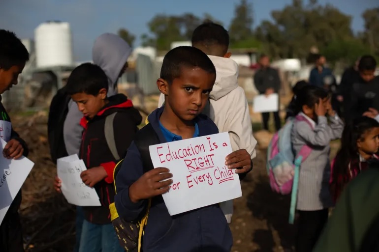 A boy in Umm al-Khair protests for his right to an education