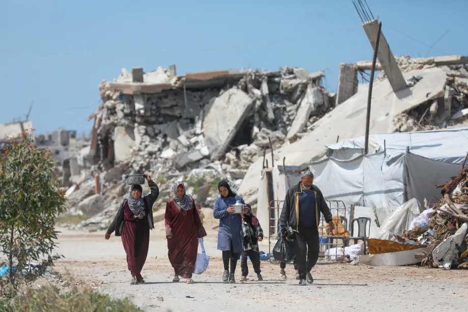 Palestinians walk amid the rubble left behind by Israeli attacks in Beit Lahia, Palestine on April 11, 2026. 

