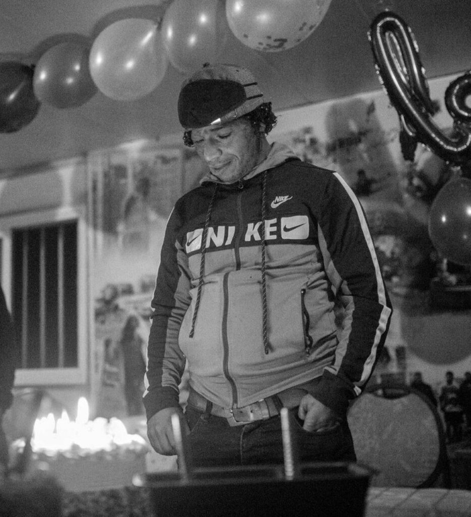 A young man in a Nike sweatshirt at a party.