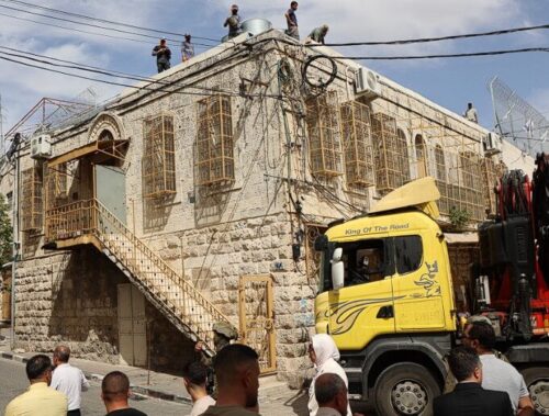 This image depicts construction work being carried out by Israeli authorities on the roof of the historic Hebron Municipality building in the Ein al-Askar area of the Old City of Hebron