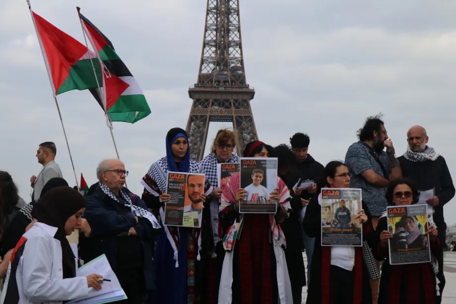 Pro-Palestinian demonstrators hold posters bearing the faces and names of Palestinians who lost their lives in Israeli attacks on Gaza, during a commemoration near the Eiffel Tower in Paris, France, on May 15, 2024.