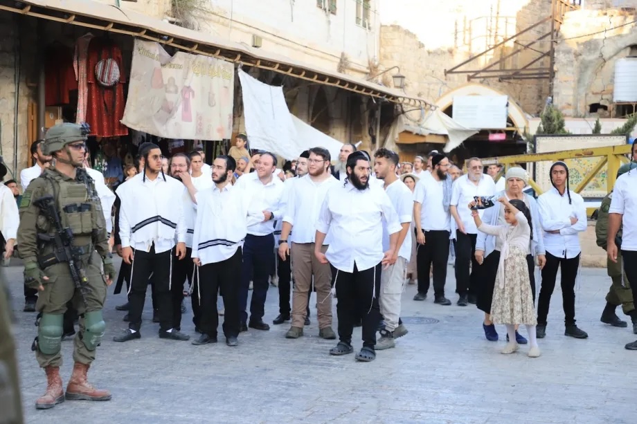 Jewish settlers, under the protection of Israeli forces, stage a raid in the Old City of Hebron, West Bank. 