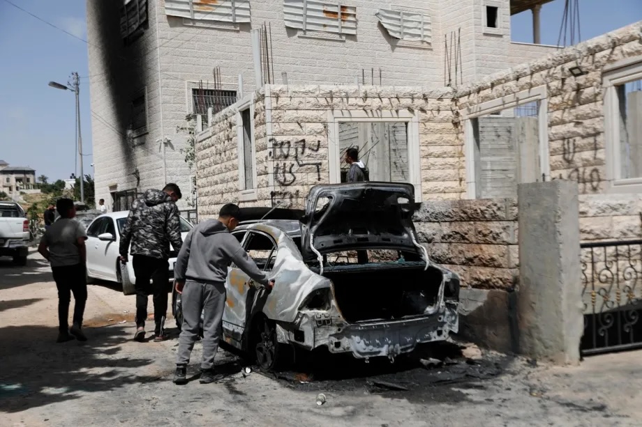 Palestinians inspect the scale of destruction after Israeli forces set fire to two Palestinian-owned vehicles in the village of Halhul, Hebron, West Bank, Palestine on May 20, 2026.