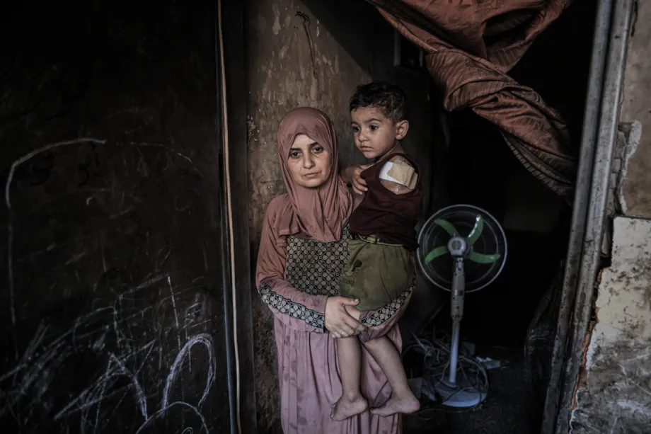A woman holds her child in her arms.