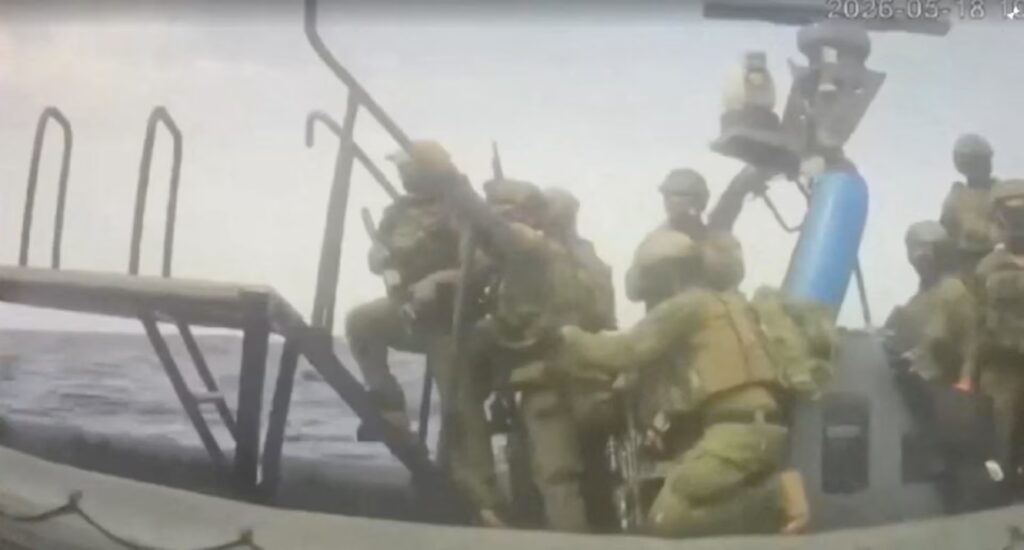 Israeli navy men storm up a ladder.