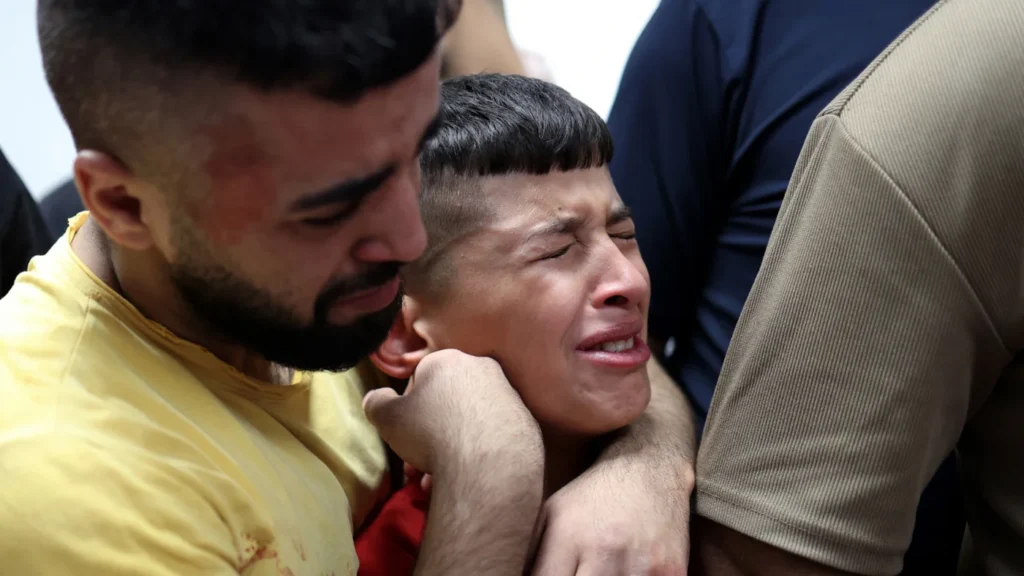 Crying child being held tightly by an older male.