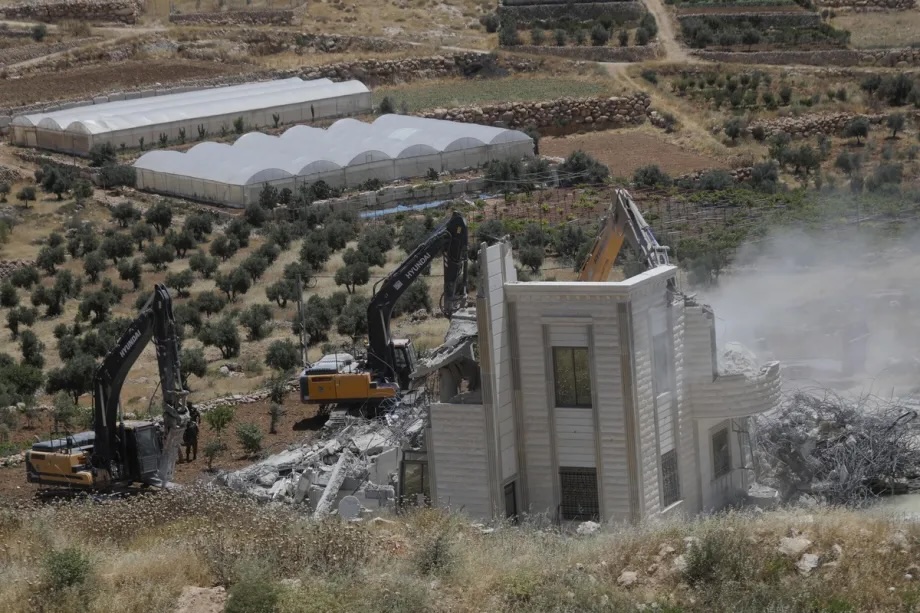 Israeli army heavy machinery demolishes a 2-story Palestinian house belonging to Nayif Abu Sneineh, as Israeli soldiers take security measures in Qalqas village, south of the West Bank city of Hebron, Palestine on June 08, 2026.