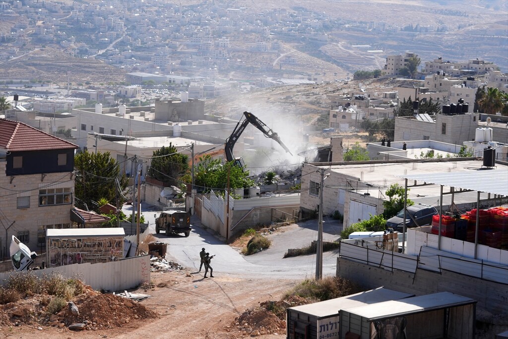 Israeli forces take security measures as municipal bulldozers escorted by Israeli forces demolish a two-story residential building and a commercial business belonging to a local Palestinian resident, Ziyad Sultan in the town of Jaba
