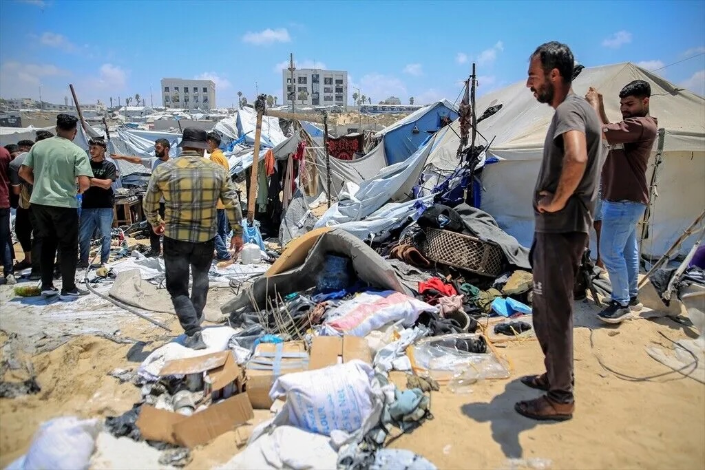 Displaced Palestinians inspect the aftermath of an Israeli strike on a tent encampment for displaced Palestinians in Gaza City on July 7, 2026, killing at least one person.