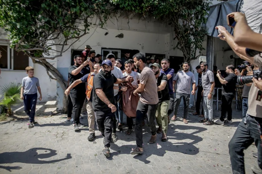Palestinians carry casualties to nearby hospitals following an Israeli attack targeting a municipal police facility in central Gaza City, Gaza, on August 19, 2026.