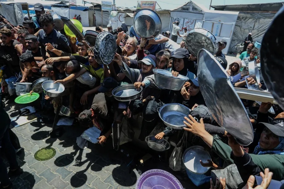 Displaced Palestinians gather to receive meals distributed by a charity in the Al-Mawasi area as food shortages continue amid ongoing Israeli attacks and the blockade of the Gaza Strip in Khan Yunis, Gaza, Palestine, on July 10, 2026.