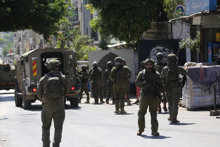 Israeli soldiers carrying rifles patrol a street during a raid on Balata Refugee Camp in Nablus, West Bank, Palestine, on June 18, 2026.