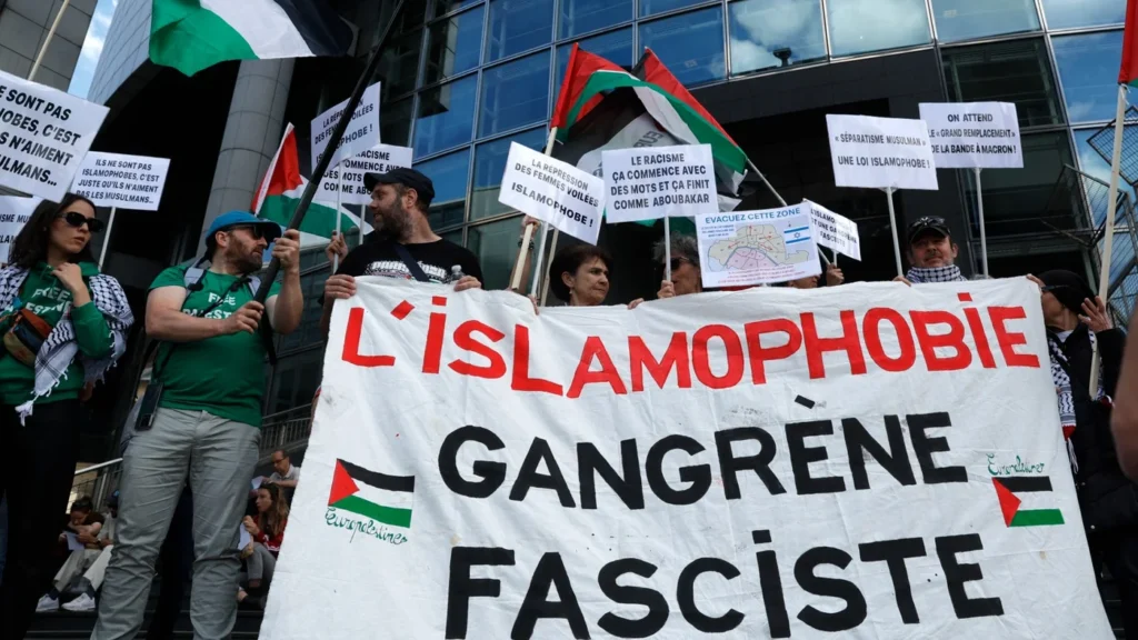 Protesters stand behind a banner reading 'islamophobia, fascist gangrene' during a rally against Islamophobia, in Paris on 11 May 2025