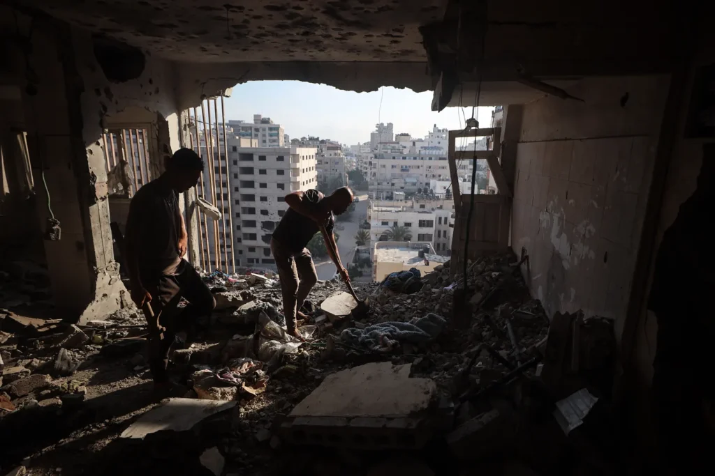 Ahmed Abu Al-Kas (right) at the site of an Israeli airstrike that targeted Al-Sousi tower in Gaza City on August 2, 2026.