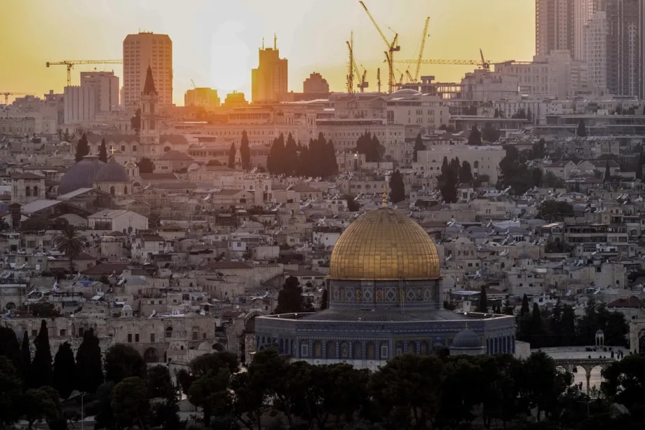 The reddish glow of sunset illuminates the Dome of the Rock Mosque in the Al-Aqsa Mosque compound, viewed from the Mount of Olives in Jerusalem on August 20, 2026.